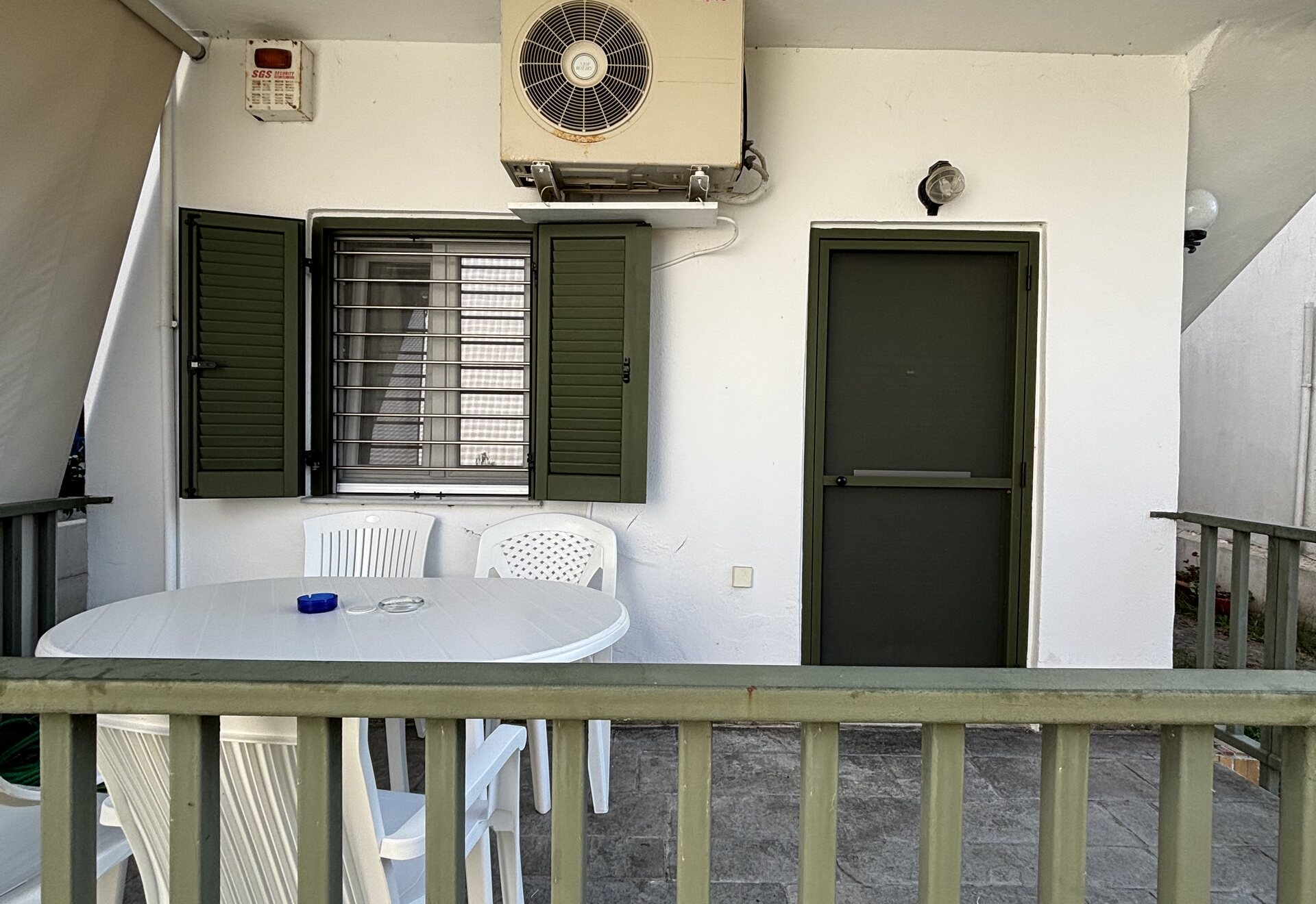 Polychrono Duplex covered terrace with outdoor table and apartment entrance