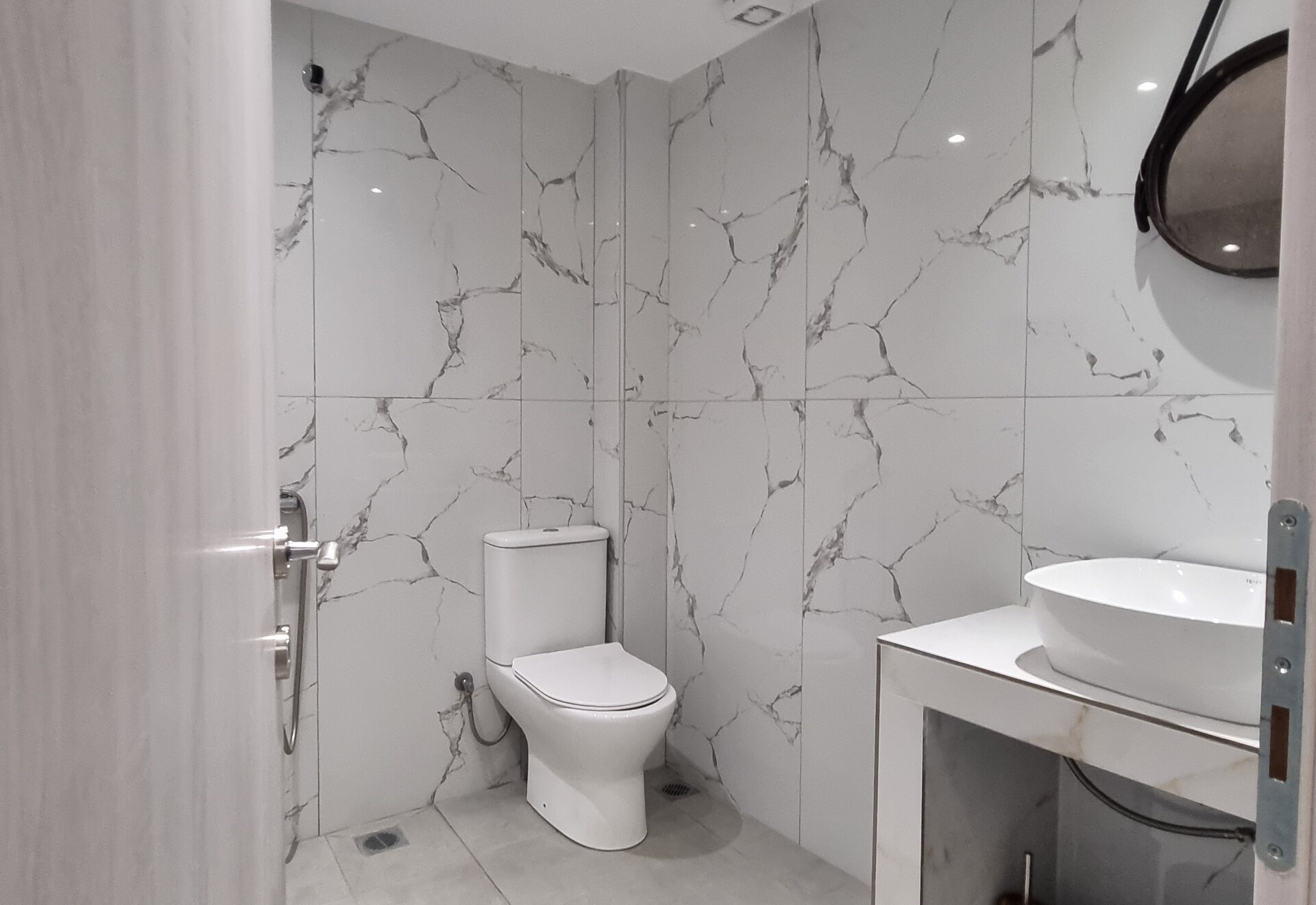 Polychrono Patio Retreat bathroom with shower, vanity, and toilet