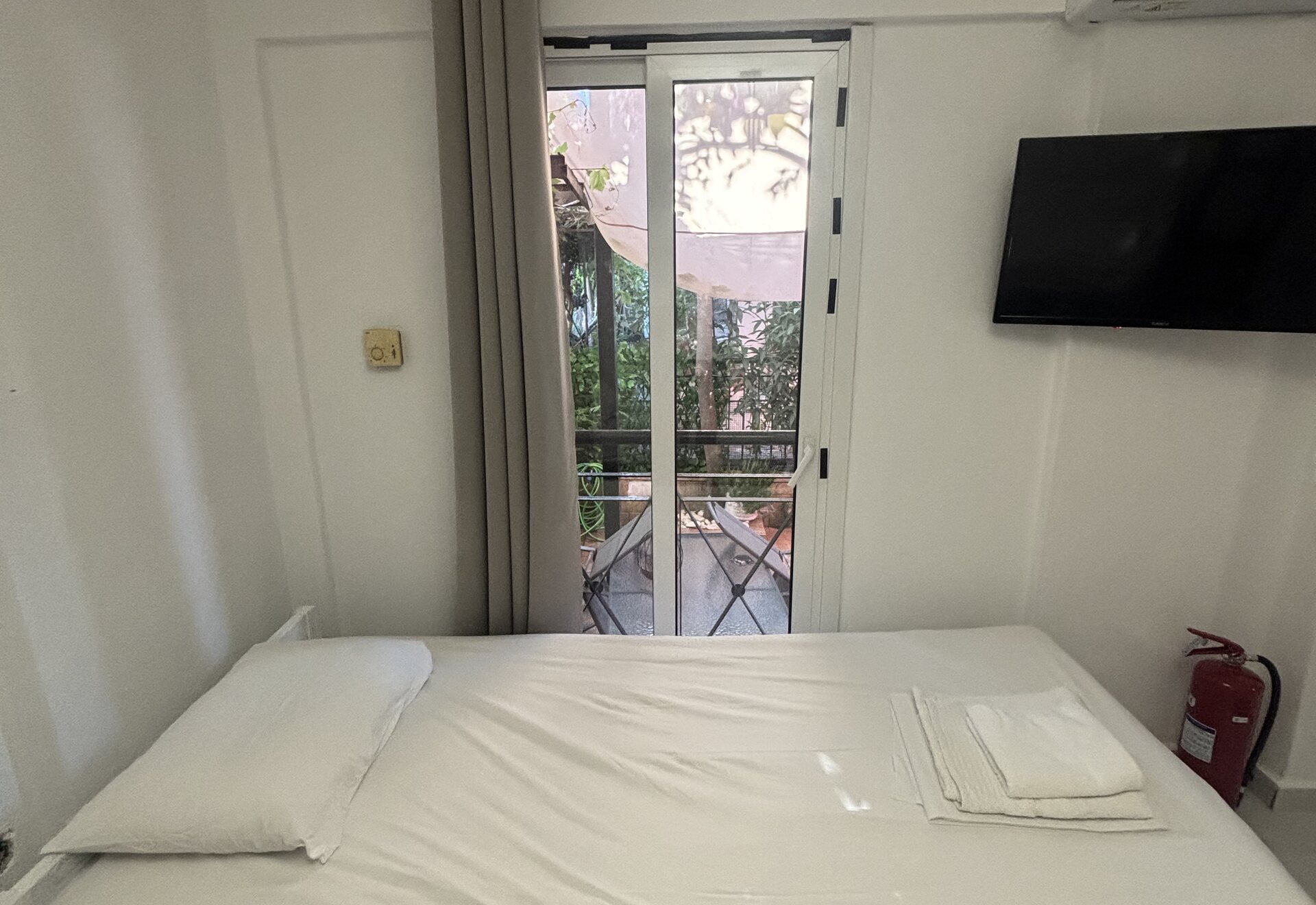 Polychrono Patio Retreat sleeping area with patio door and wall-mounted TV