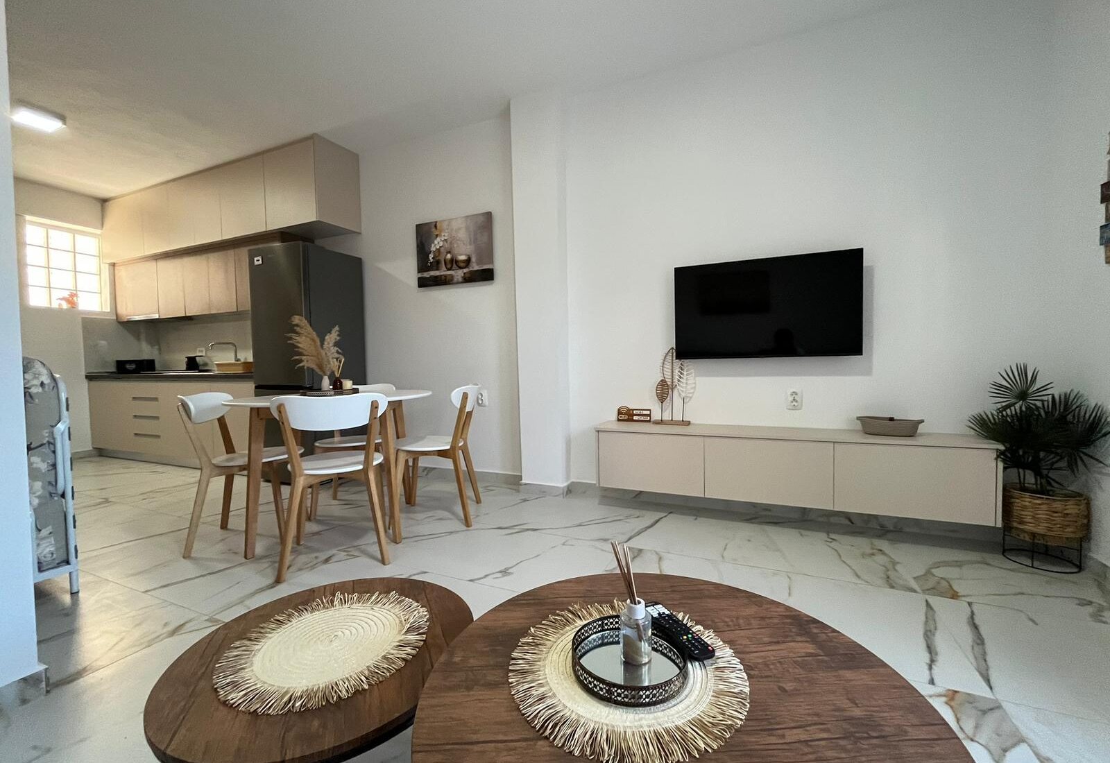 Aegean Dream living room with kitchen, dining table, and TV