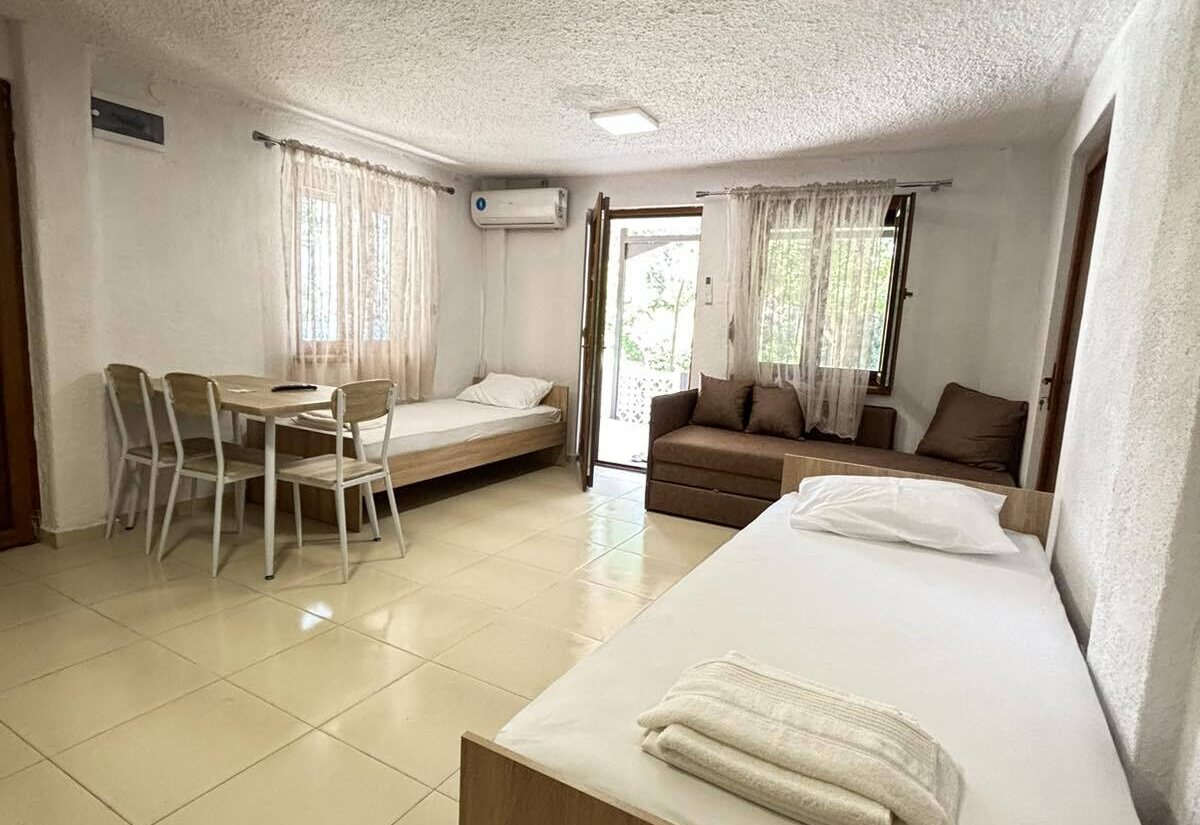 Garden Haven Apartment with Garden View open living area with twin beds, sofa, and dining area