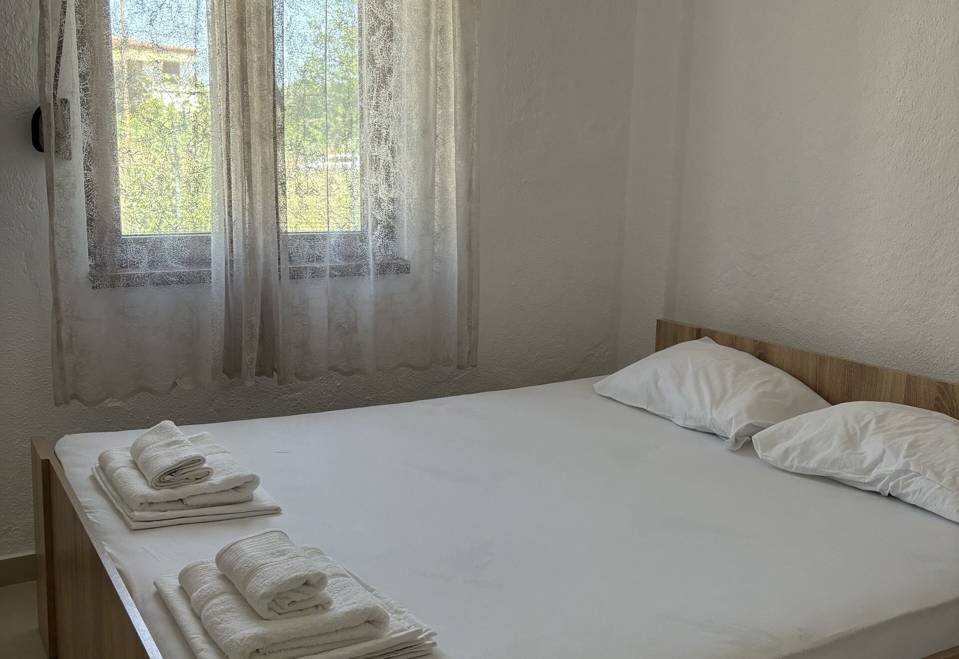 Garden Haven Two-Bedroom Apartment with Garden View double bedroom with window and towels on the bed