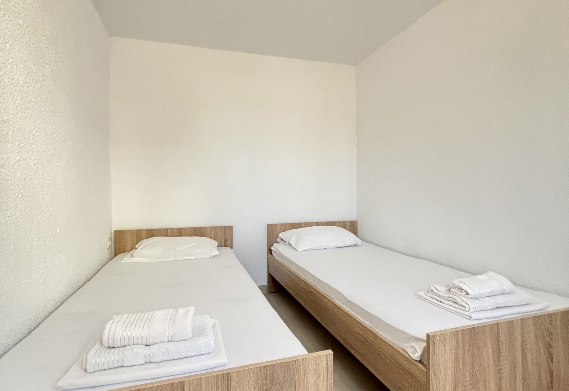Garden Haven Two-Bedroom Apartment with Garden View twin bedroom beds with folded towels