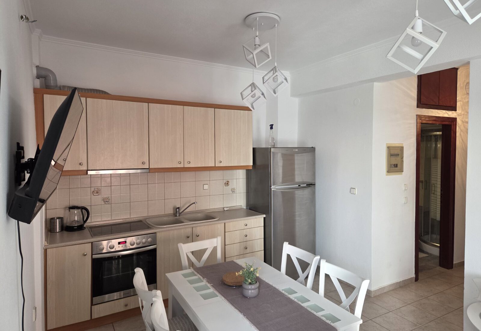 Polychrono Two Bedroom Apartment kitchen and dining table with oven and refrigerator