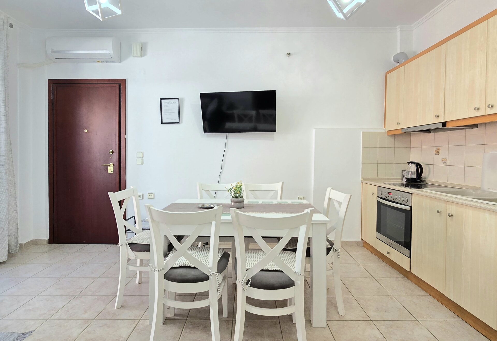 Polychrono Two Bedroom Apartment kitchen with dining table and wall-mounted TV